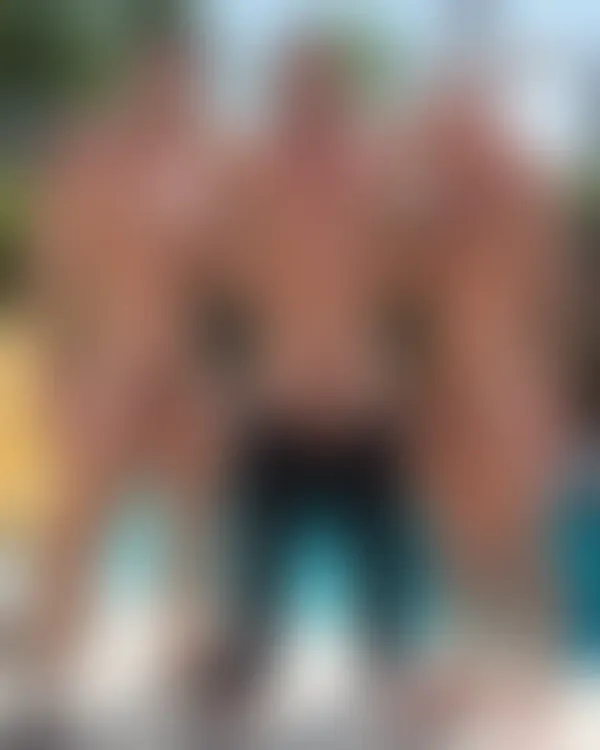 Three sun-drenched, shirtless muscular men standing shoulder-to-shoulder by a sparkling pool with arms around each other