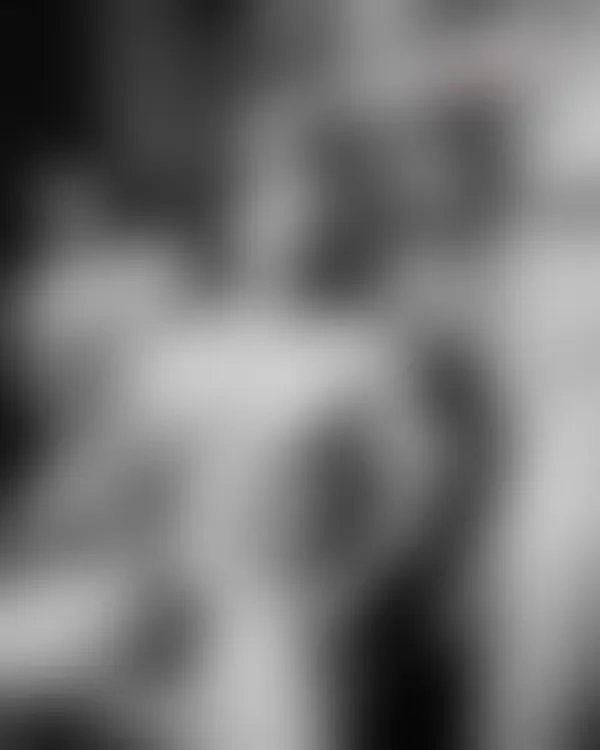Four shirtless muscular men in a dimly lit locker room with intense locked gazes and sweat-slicked skin under dramatic l